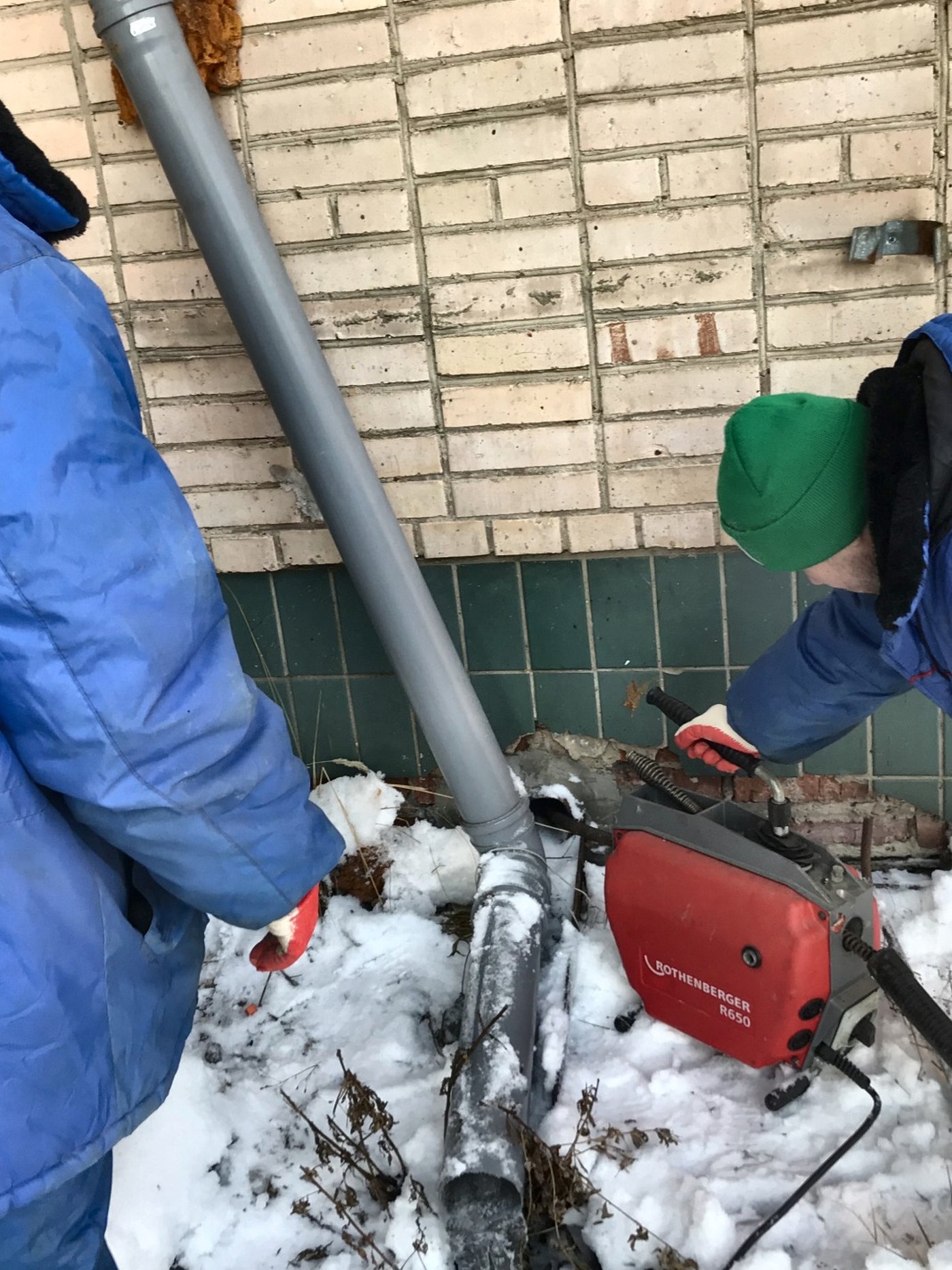 ANKOR crew clearing an exterior drain line with a Rothenberger drain machine